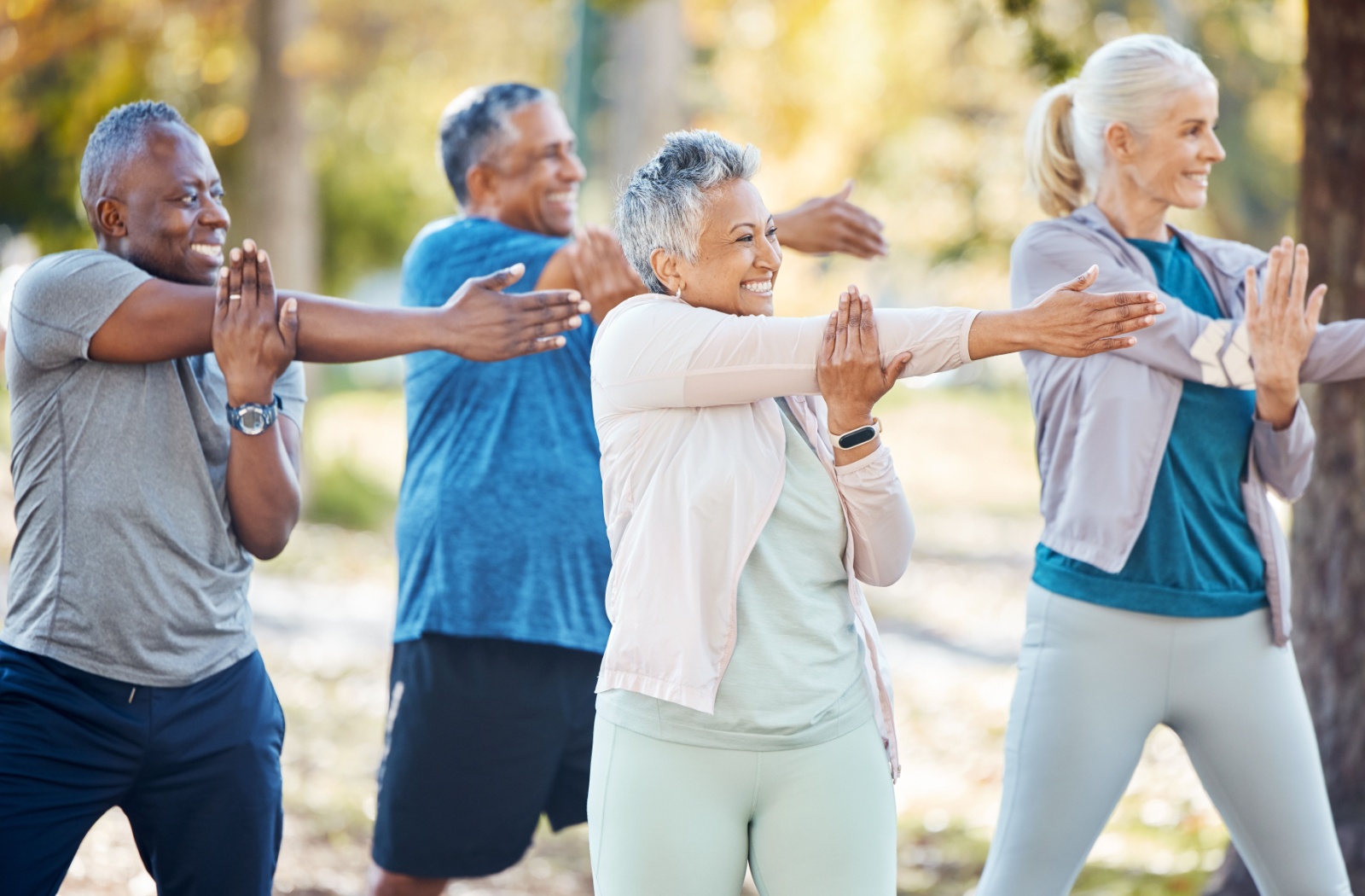 Senior people stretching before an exercise in an outdoor park or nature.
